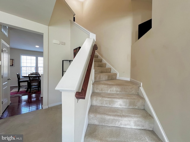 stairway with baseboards and carpet