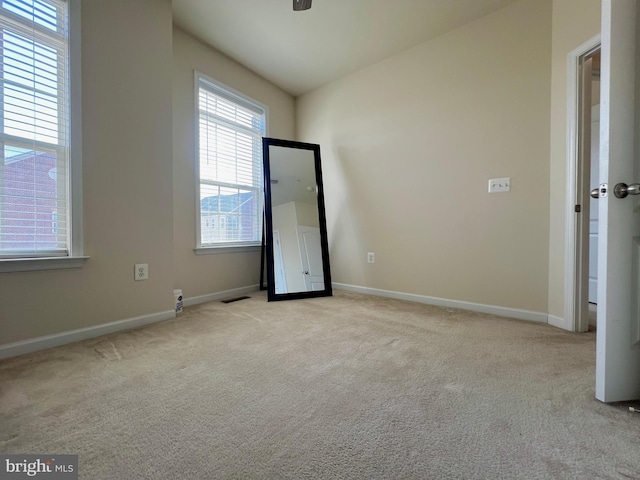 unfurnished room with visible vents, baseboards, and carpet flooring