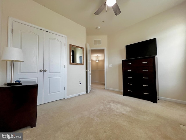 bedroom with light carpet, visible vents, baseboards, and a closet