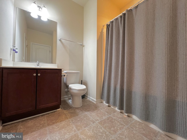 bathroom with a shower with curtain, toilet, vanity, and baseboards