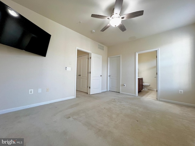 unfurnished bedroom featuring visible vents, baseboards, light colored carpet, and ensuite bathroom