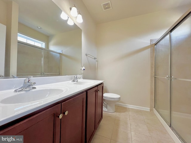 bathroom featuring tile patterned flooring, visible vents, an enclosed shower, and a sink