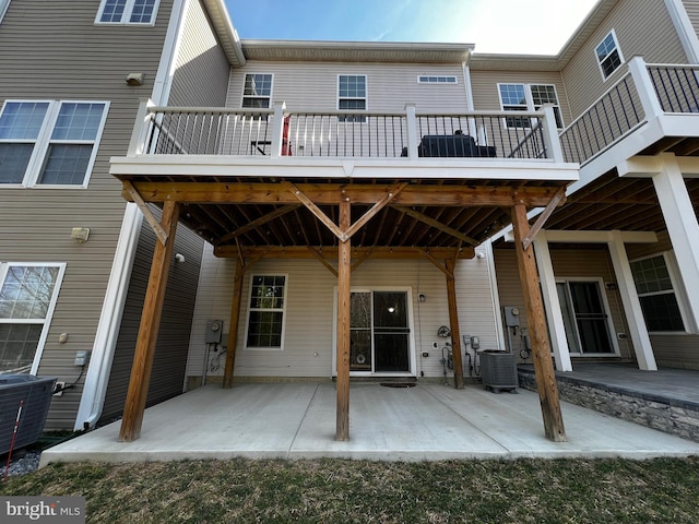 rear view of property with a wooden deck, central AC, and a patio area