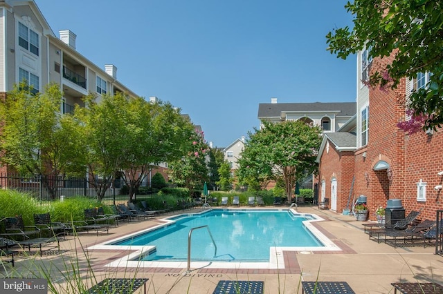 pool featuring a grill, a patio, and fence