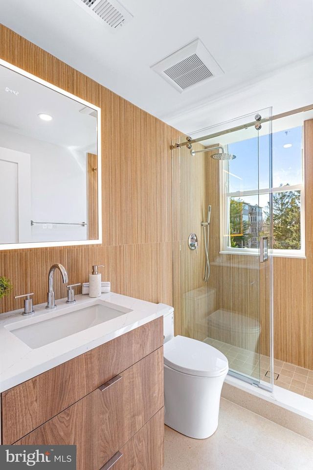 bathroom featuring vanity, toilet, visible vents, and a stall shower