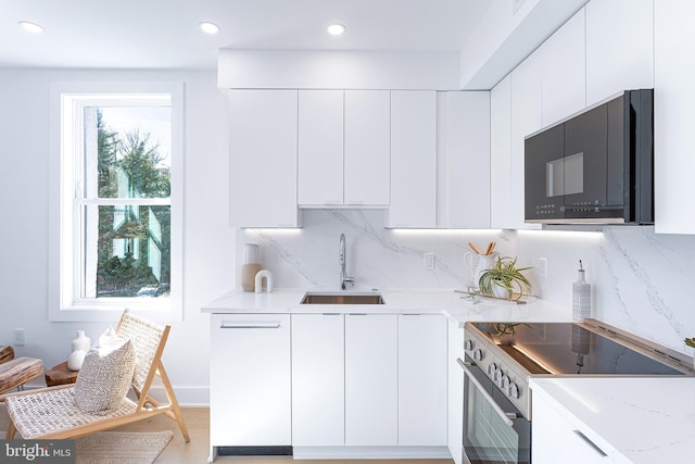 kitchen with stainless steel electric range oven, modern cabinets, and a sink