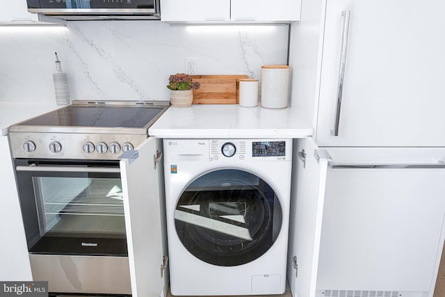 clothes washing area featuring washer / dryer and laundry area