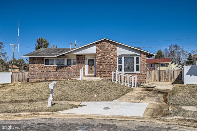 view of front of property featuring brick siding and fence