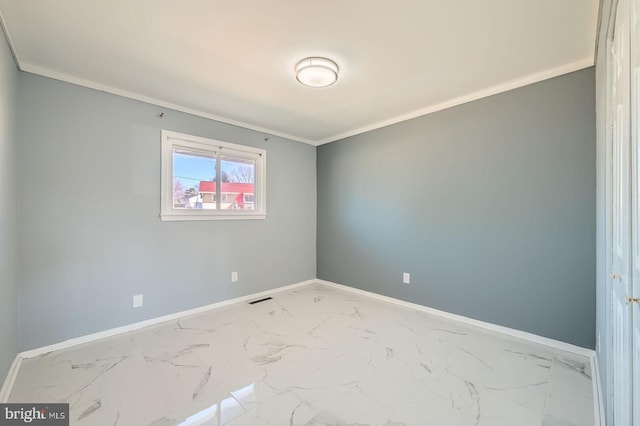 spare room featuring visible vents, baseboards, marble finish floor, and ornamental molding