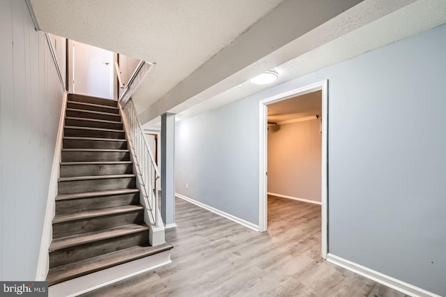 stairs with baseboards and wood finished floors