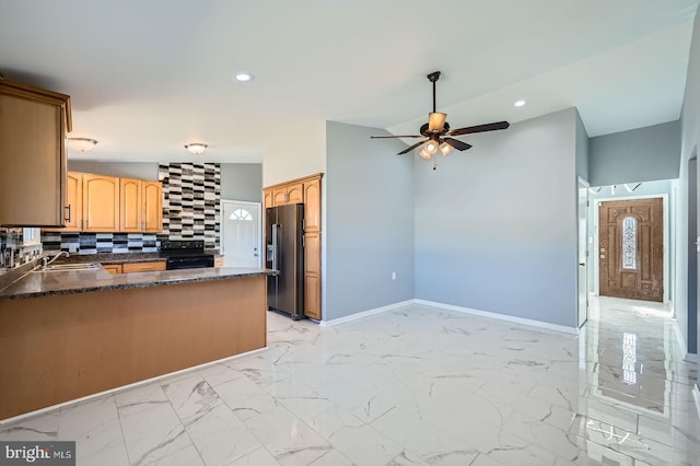 kitchen featuring backsplash, fridge with ice dispenser, marble finish floor, black electric range oven, and a sink