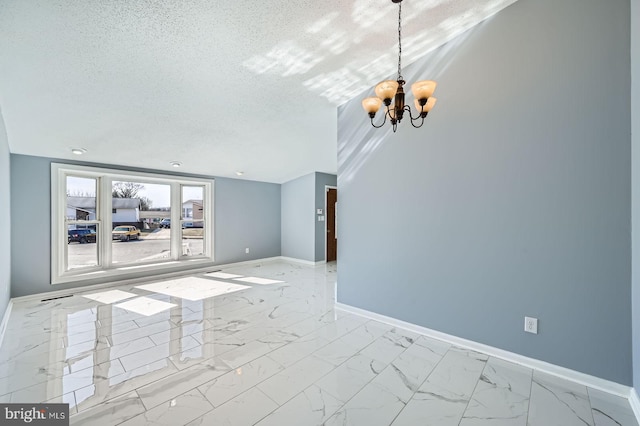 empty room featuring baseboards, a textured ceiling, marble finish floor, and an inviting chandelier