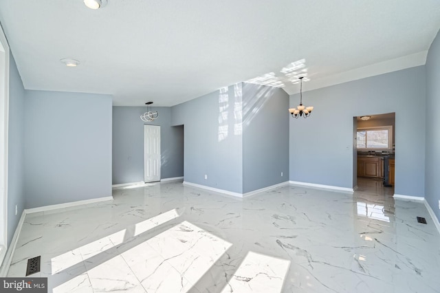 spare room with visible vents, baseboards, marble finish floor, and a chandelier