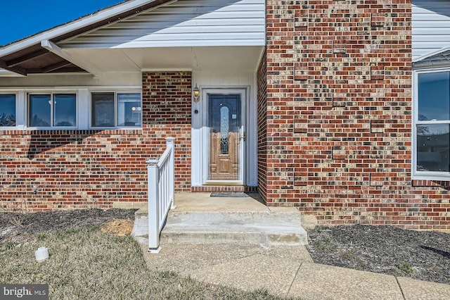 doorway to property featuring brick siding