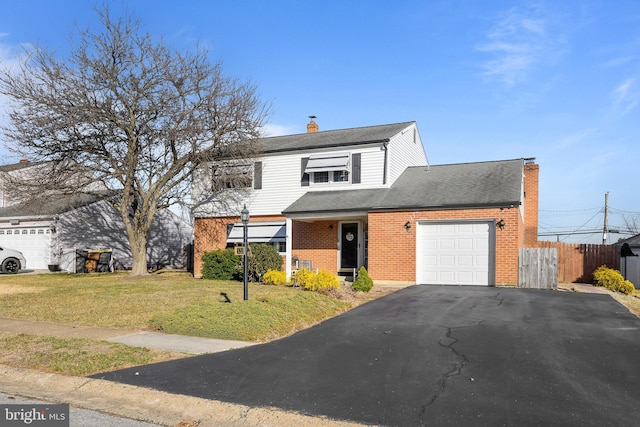 traditional-style house featuring brick siding, fence, a front yard, a chimney, and an attached garage