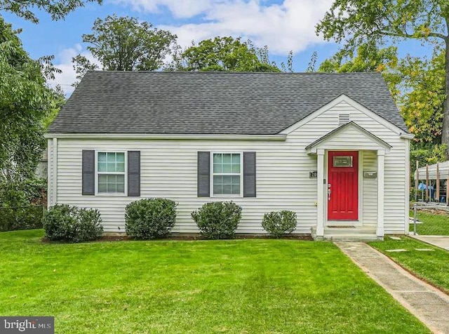 view of front of house featuring a front lawn and roof with shingles