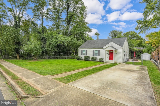 view of front of property featuring a front yard, fence, driveway, entry steps, and an outdoor structure