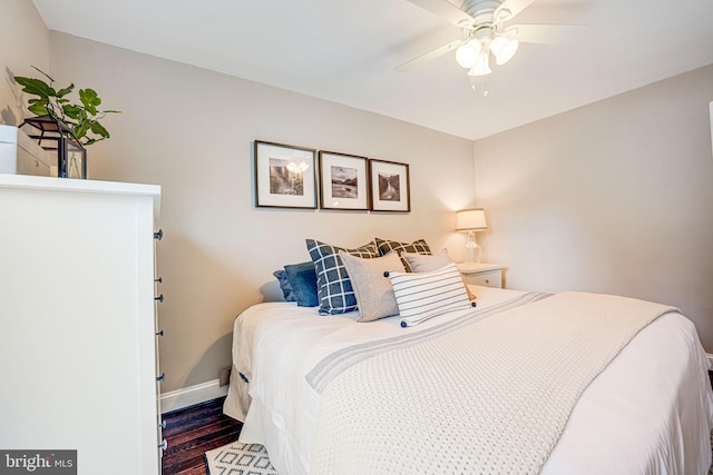 bedroom with ceiling fan, baseboards, and dark wood-style flooring