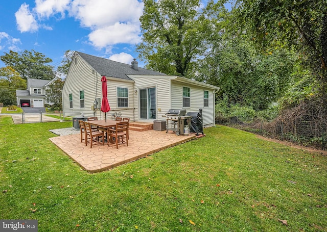 rear view of property featuring a yard, a patio, and a chimney