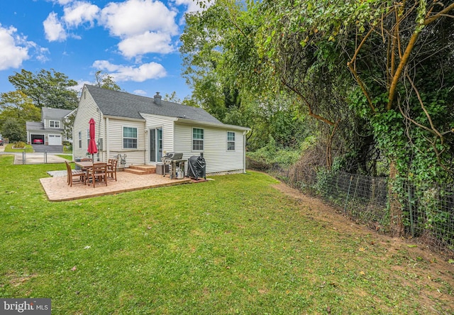 rear view of property featuring entry steps, a patio area, a yard, and fence