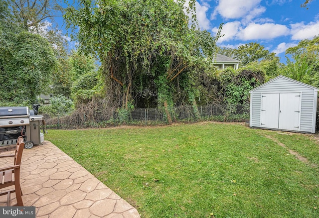 view of yard featuring an outbuilding, a shed, a patio area, and fence