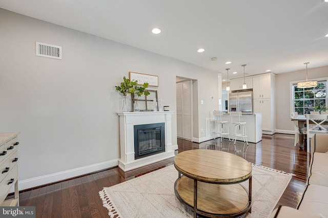 living room with recessed lighting, visible vents, baseboards, and dark wood-style flooring