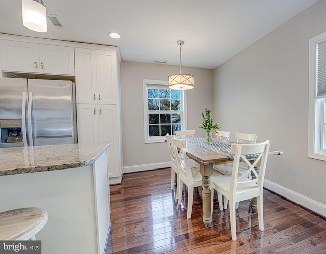 dining area featuring dark wood-style floors, visible vents, and baseboards