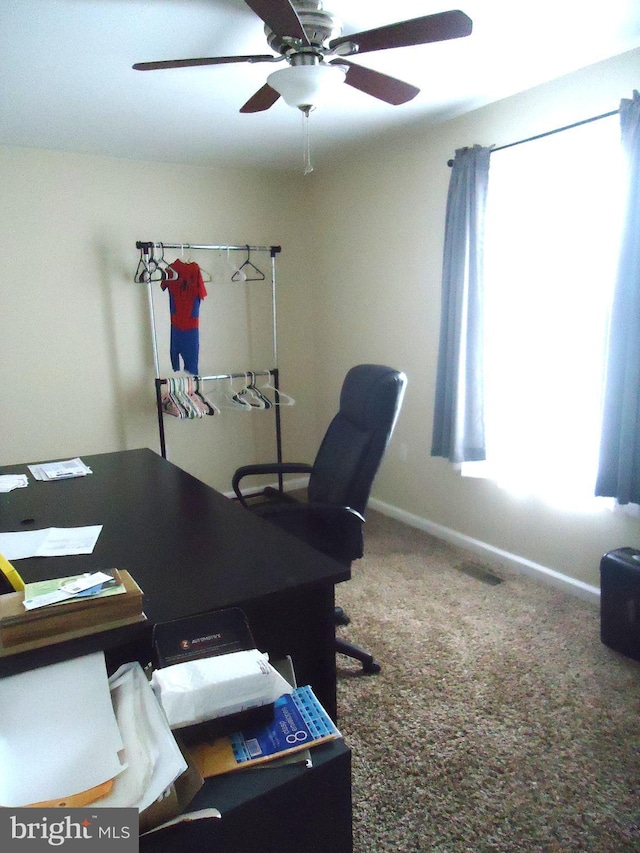 office area featuring a healthy amount of sunlight, baseboards, carpet floors, and ceiling fan