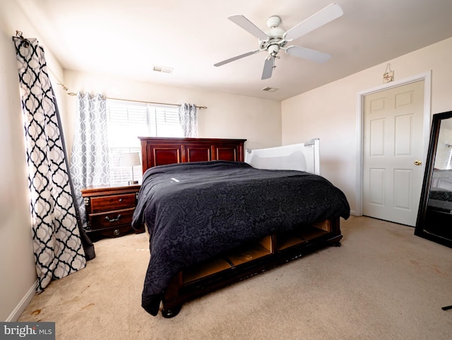 carpeted bedroom with visible vents, baseboards, and a ceiling fan