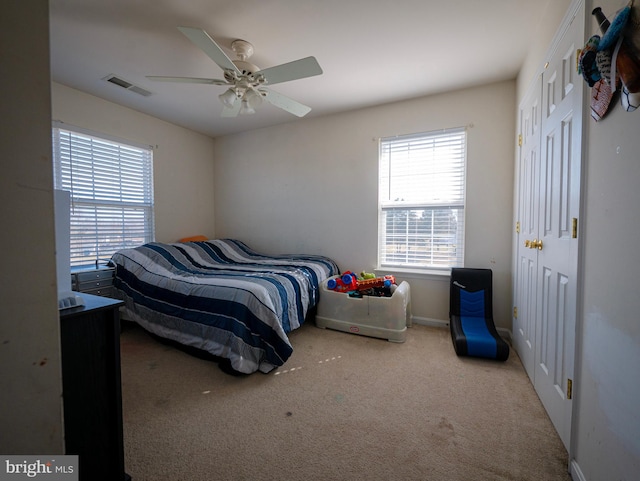 carpeted bedroom with baseboards, visible vents, and ceiling fan