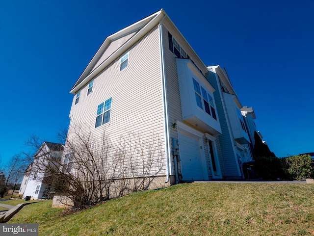 view of property exterior with a lawn and an attached garage