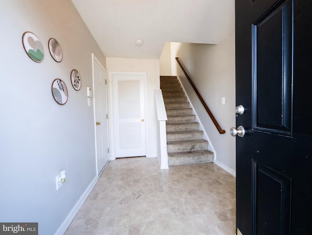 entrance foyer featuring stairs and baseboards