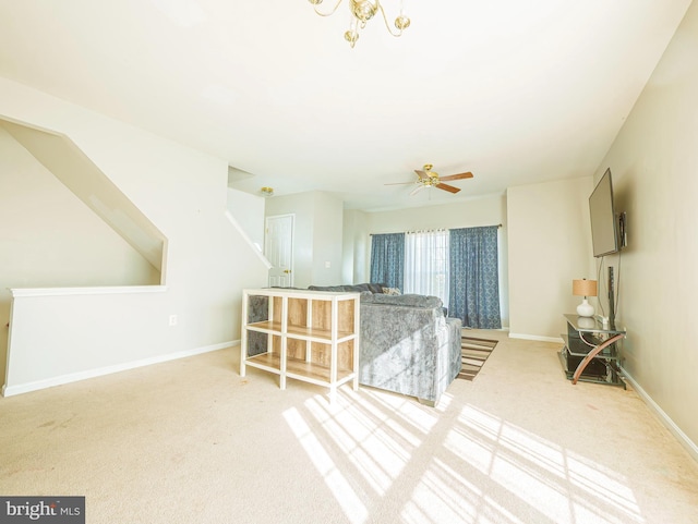 unfurnished living room featuring baseboards, carpet, and ceiling fan with notable chandelier