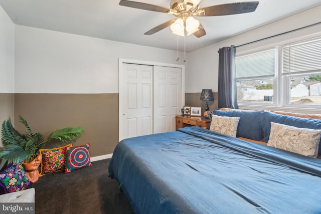 carpeted bedroom with a ceiling fan, a closet, and baseboards