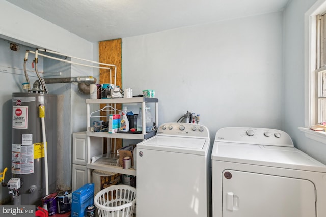 washroom featuring laundry area, water heater, and washer and clothes dryer