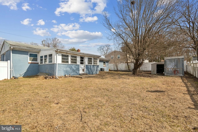 view of yard with a storage shed, an outbuilding, and a fenced backyard