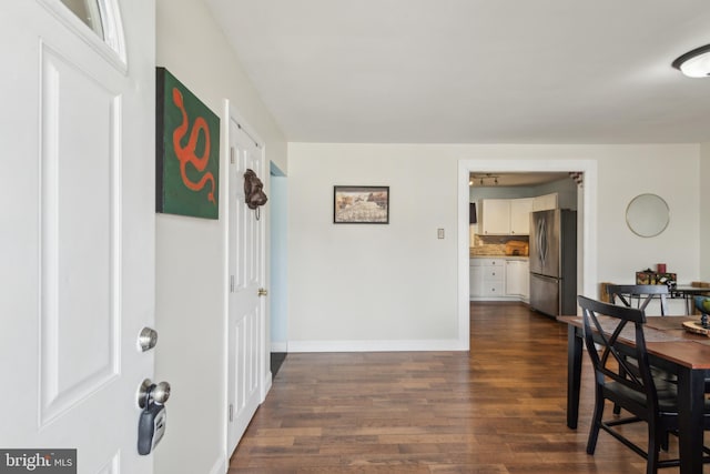 dining area featuring dark wood-style floors and baseboards