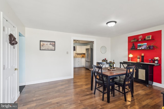 dining space with baseboards and dark wood-style flooring