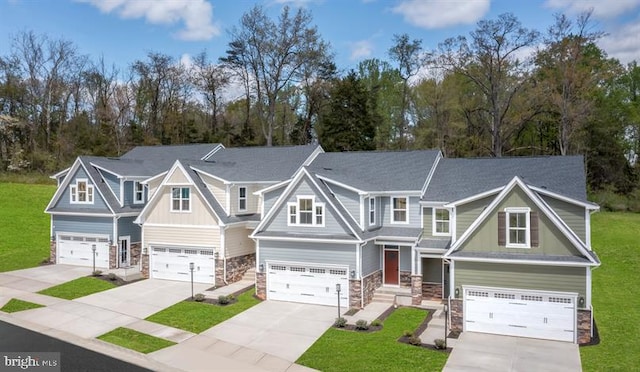 craftsman-style home featuring a front yard, a garage, stone siding, and driveway