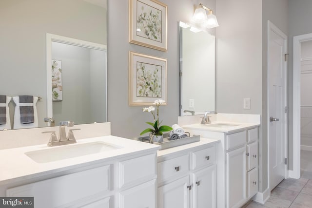 bathroom with tile patterned flooring, two vanities, and a sink