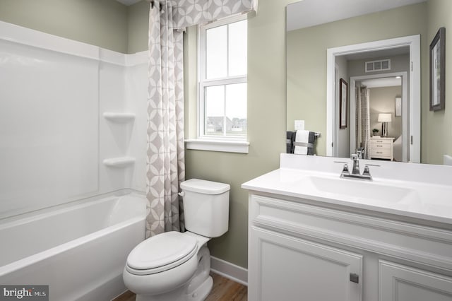 bathroom with vanity, shower / bathtub combination with curtain, visible vents, baseboards, and toilet