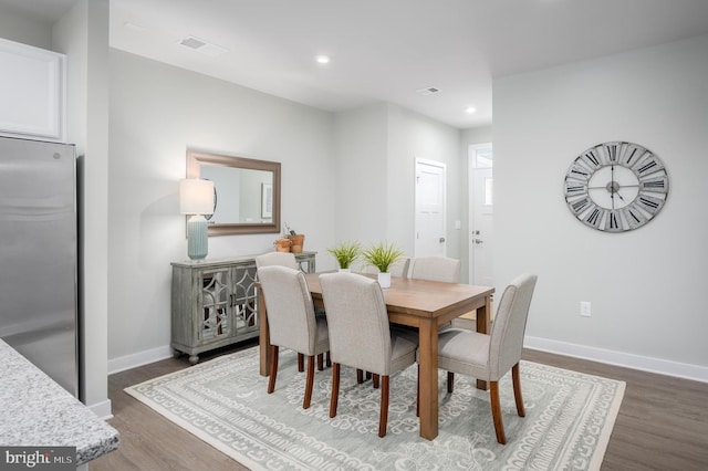 dining area with dark wood-style floors, visible vents, recessed lighting, and baseboards