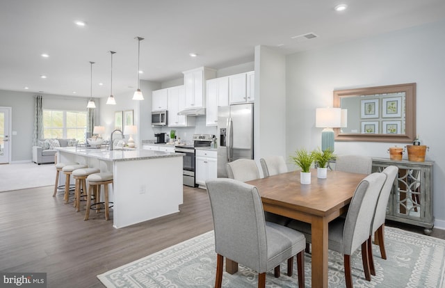 dining space featuring light wood-style flooring, recessed lighting, visible vents, and baseboards