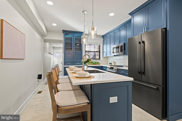 kitchen featuring a breakfast bar, blue cabinetry, premium appliances, a sink, and light countertops