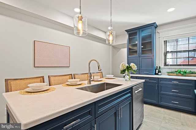 kitchen featuring dishwasher, light countertops, hanging light fixtures, blue cabinets, and a sink