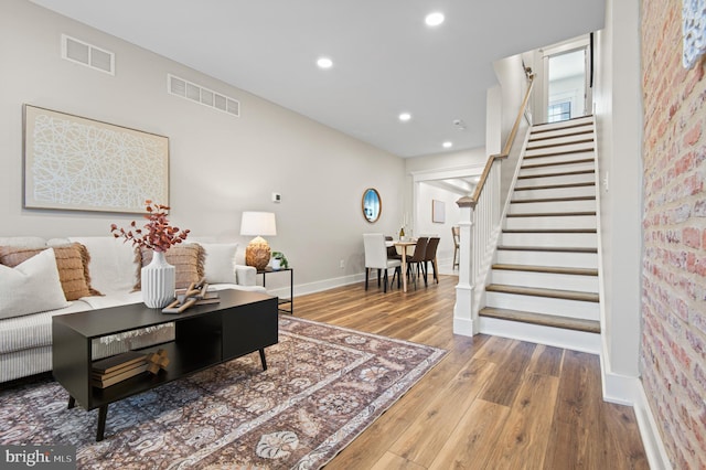 living area featuring visible vents, recessed lighting, stairs, and wood finished floors