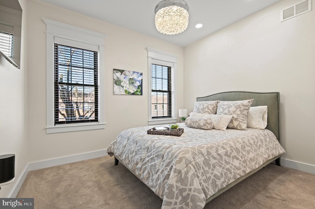 carpeted bedroom with a notable chandelier, visible vents, recessed lighting, and baseboards