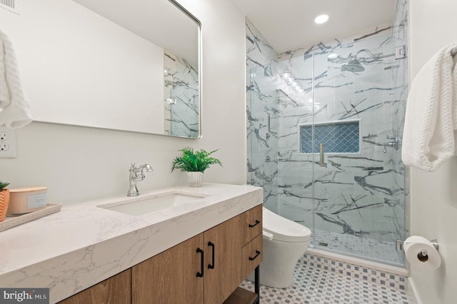 full bath with a marble finish shower, recessed lighting, toilet, and vanity