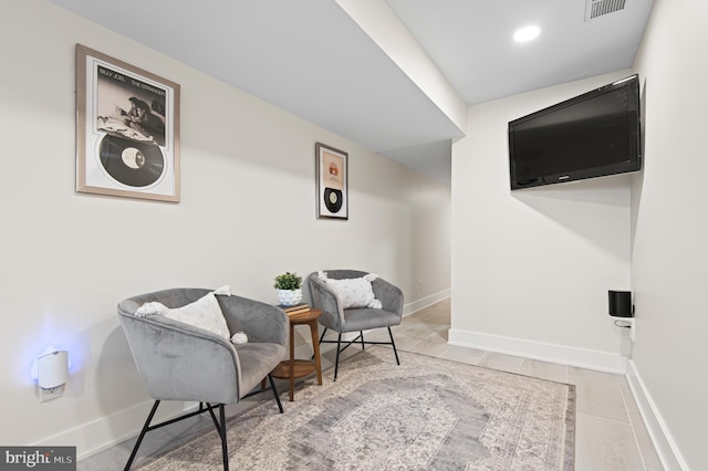 living area featuring tile patterned floors, visible vents, baseboards, and recessed lighting