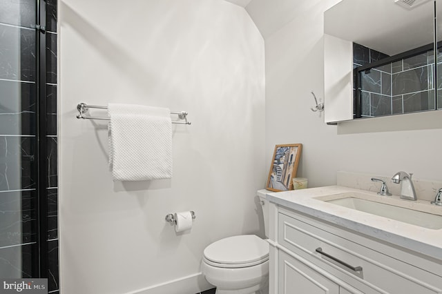 full bathroom with visible vents, toilet, a tile shower, baseboards, and vanity